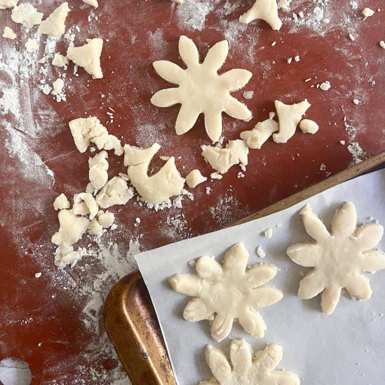 Cut out cookie dough on pastry board.