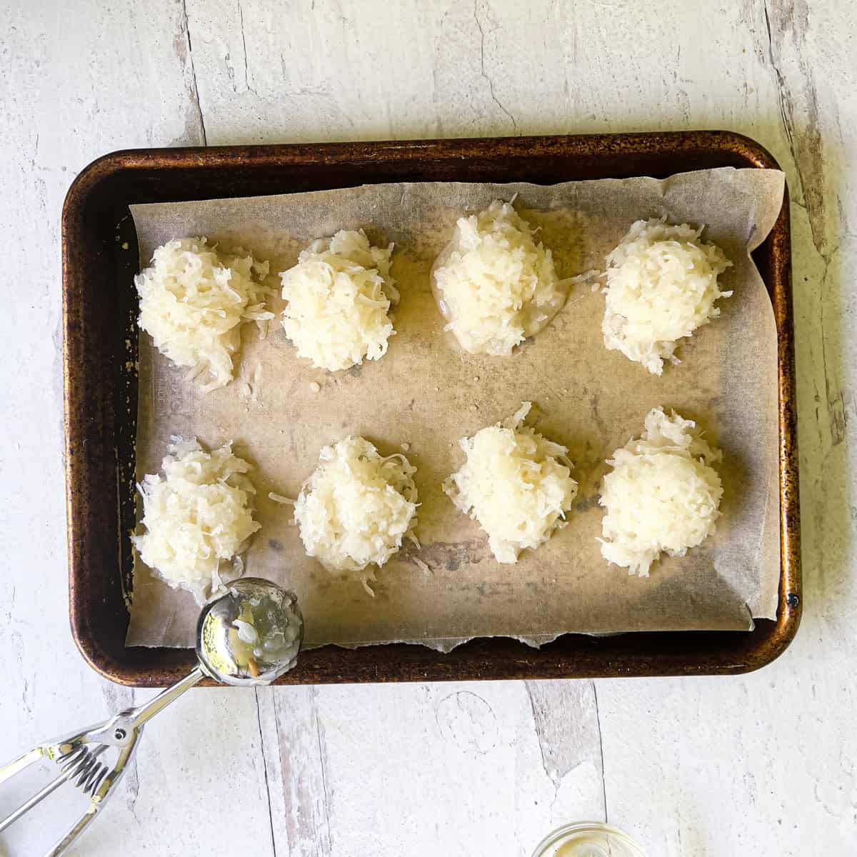 Unbaked macaroons on parchment lined baking sheet.