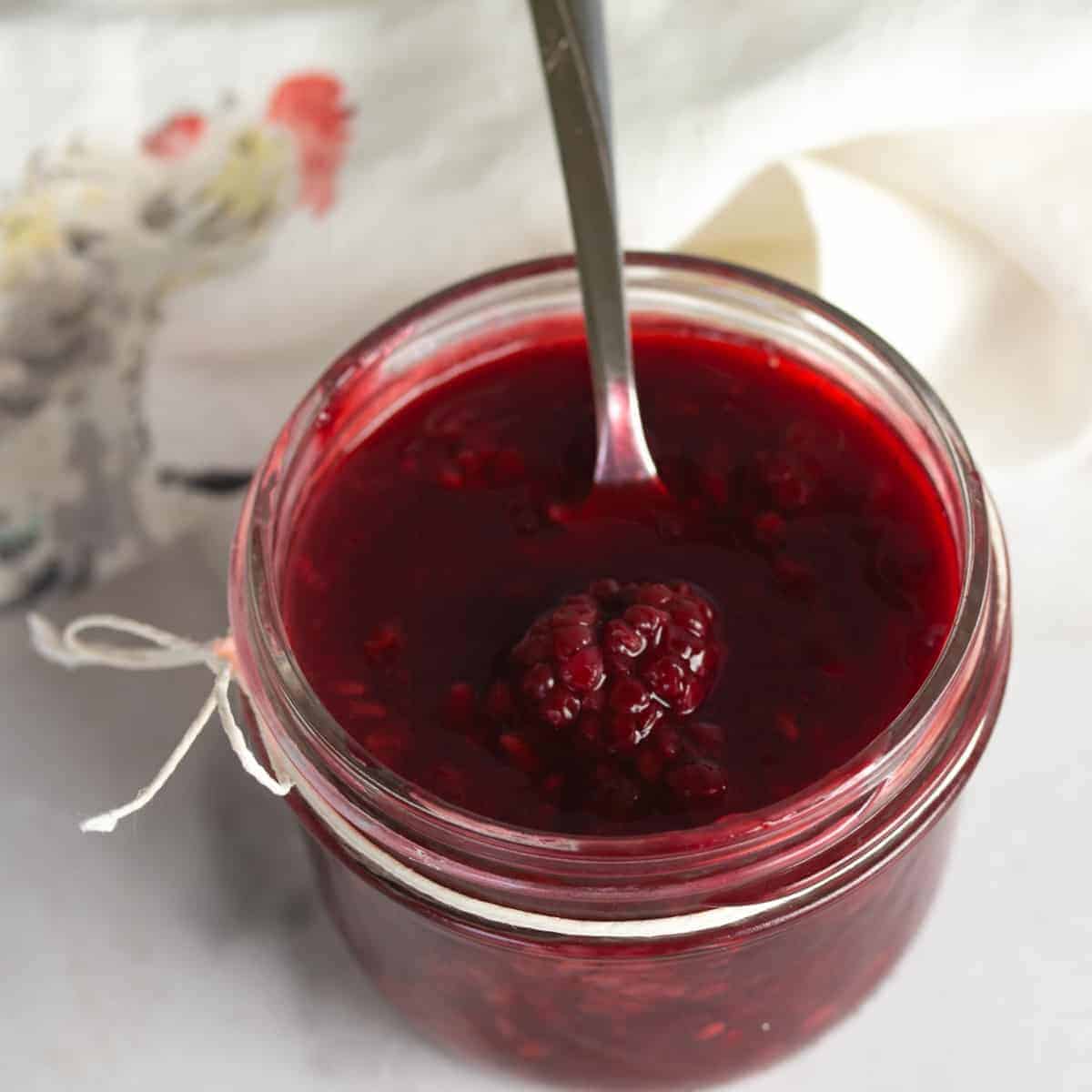 Mason jar of blackberry sauce.