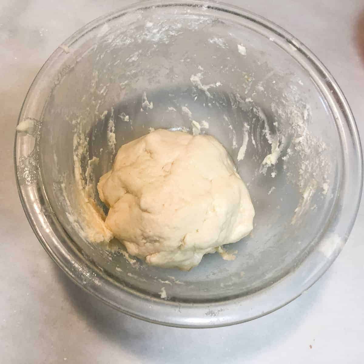 LCream cheese cookie dough in clear bowl.