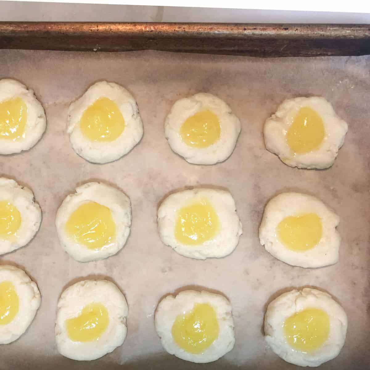 Unbaked cream cheese thumbprint cookies filled with lemon curd.