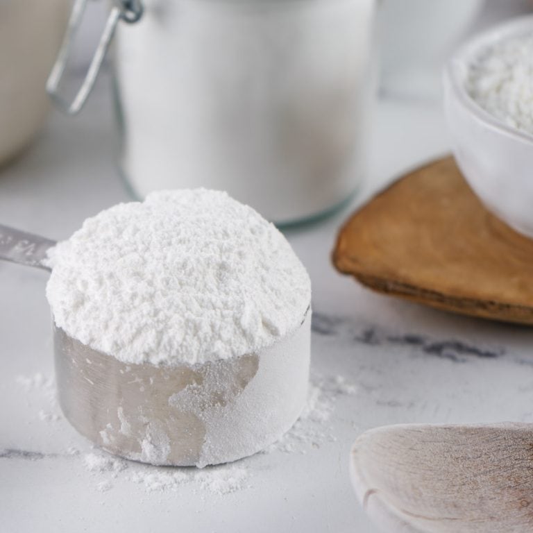 Powdered sugar in metal measuring cup.